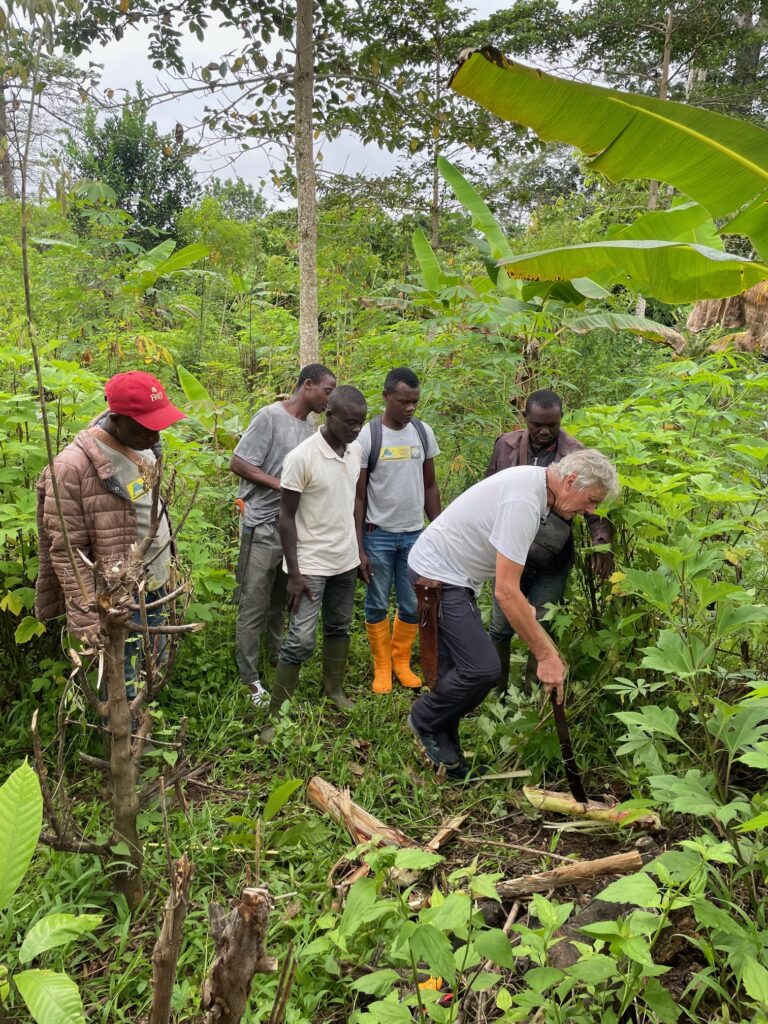 El Dr. Milz muestra cómo se riega un cultivo de plátanos a un grupo de agricultores en el campo